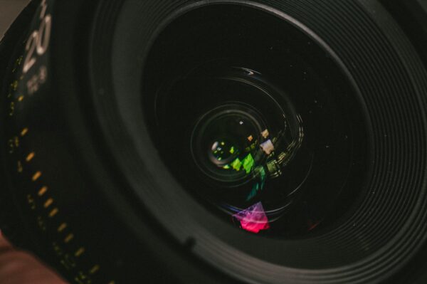 a person holding a camera lens in their hand