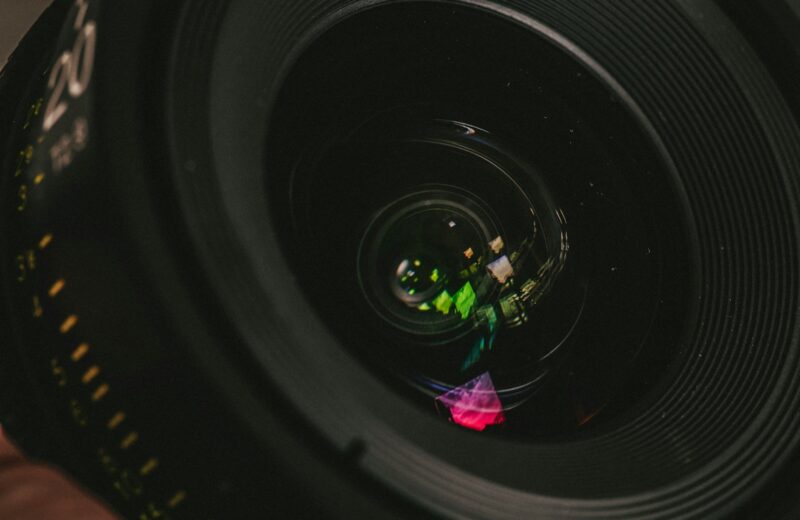 a person holding a camera lens in their hand