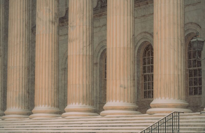 a man sitting on a bench in front of a building