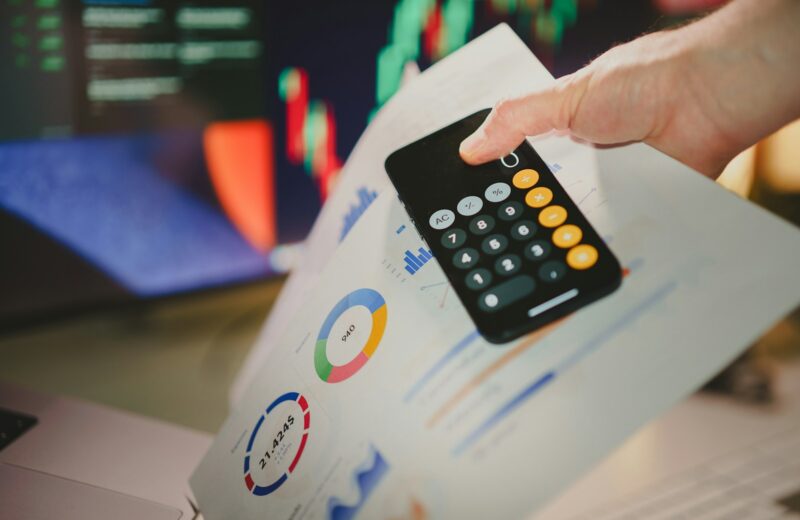 a person holding a calculator over a piece of paper