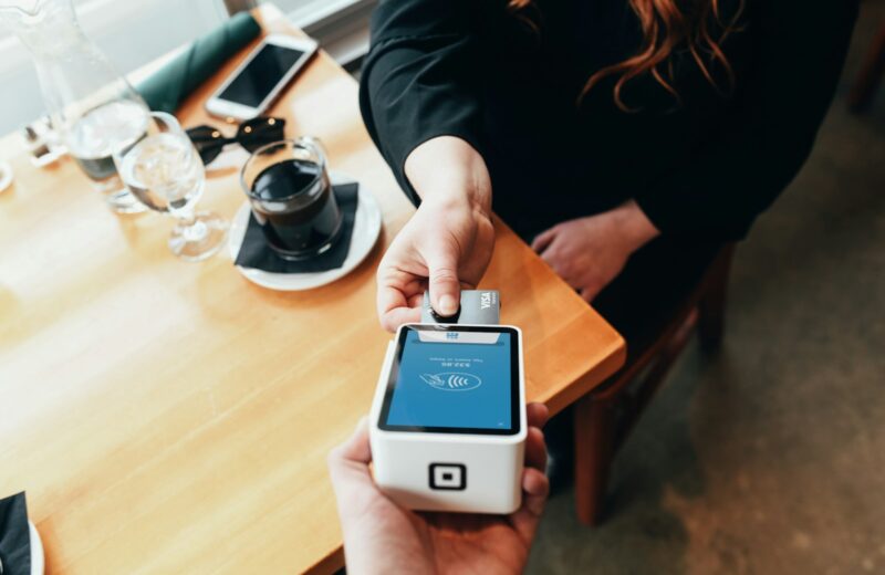 person holding credit card swipe machine