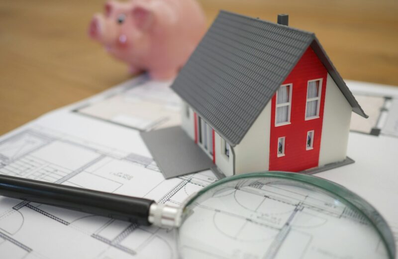 white and red wooden house beside grey framed magnifying glass